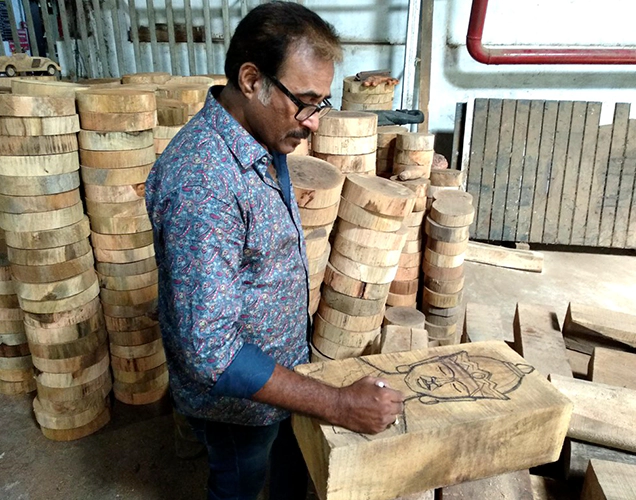 Craftsman creating wood artwork at Forms